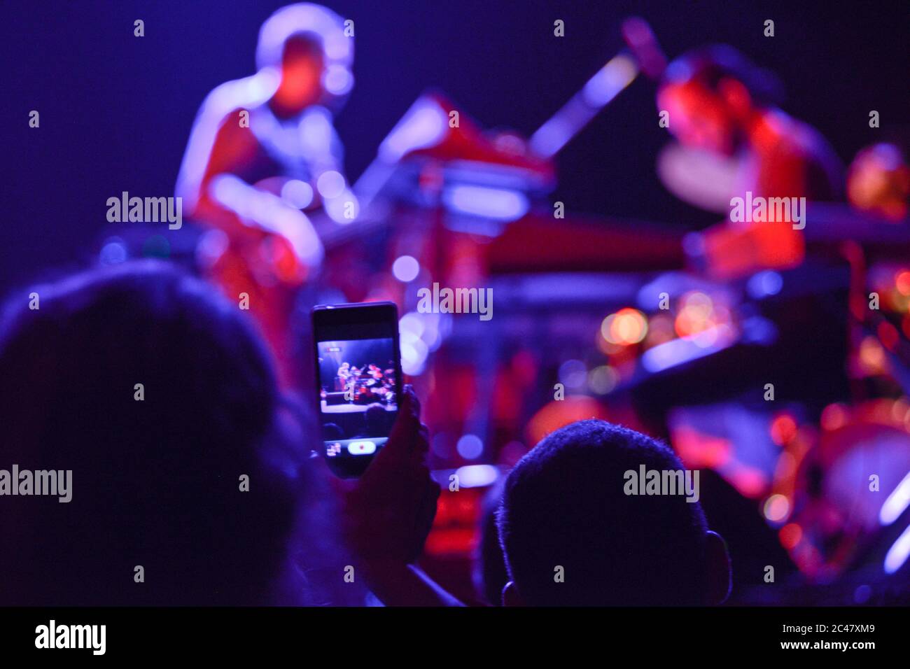 Aufnahme eines Konzerts mit dem Handy aus dem Publikum Stockfoto