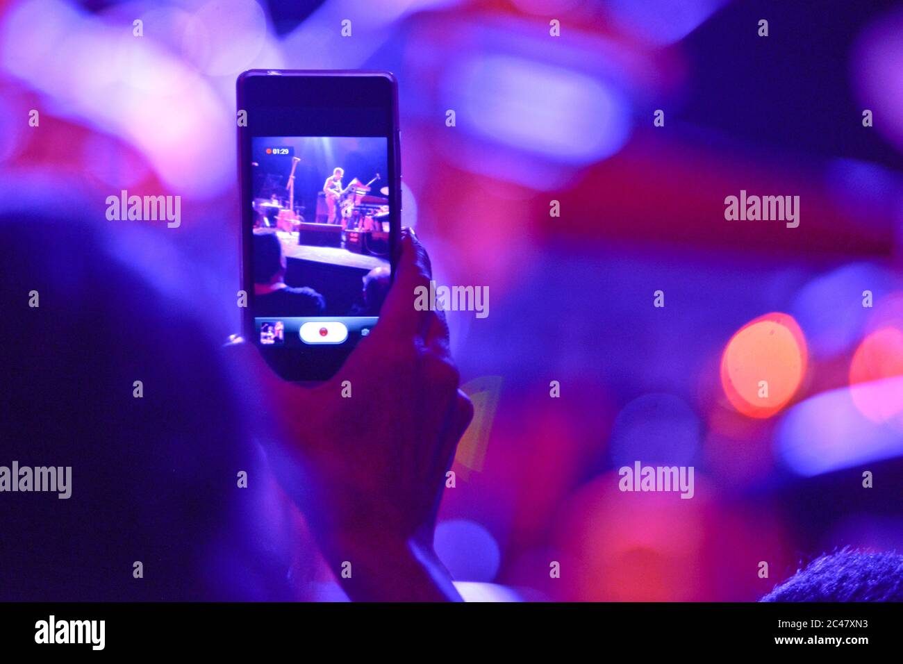 Aufnahme eines Konzerts mit dem Handy aus dem Publikum Stockfoto