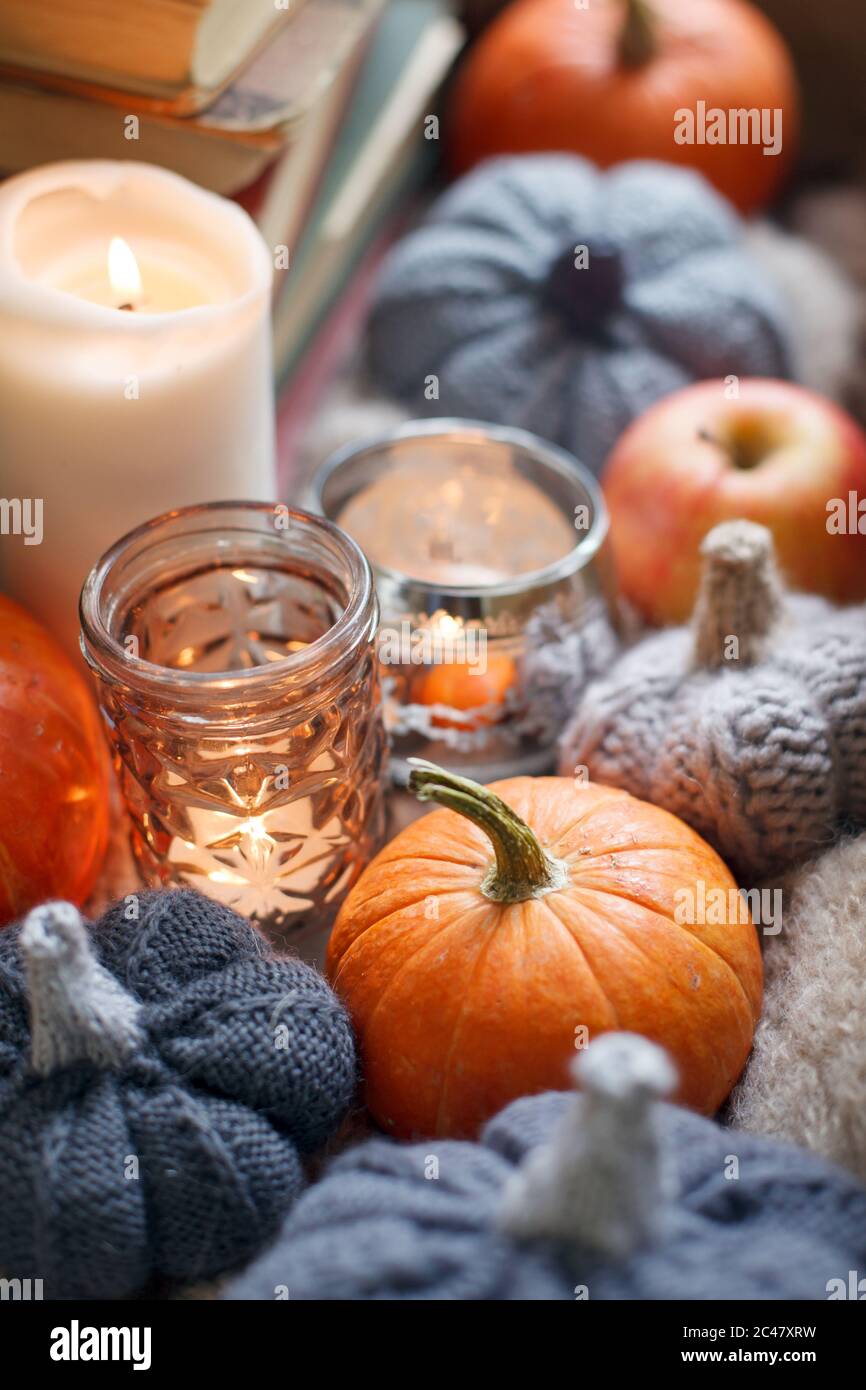 HERBSTSTIMMUNG Saisonale Herbst gemütlicher Hintergrund, fröhlicher Dankesurlaub, Kerzenkürbis und handgefertigtes Strickdekor am Fenster, warme Stimmungsstimmung Stockfoto