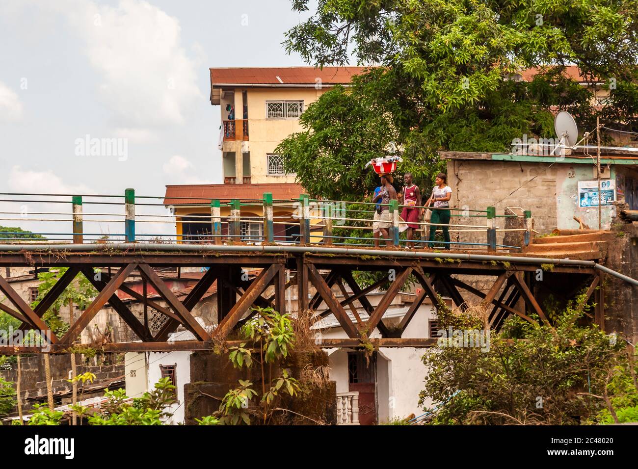 Frauen überqueren die alte Eisenbahnbrücke von Freetown, die Tengbeh Bridge, und tragen Waren auf dem Kopf Stockfoto