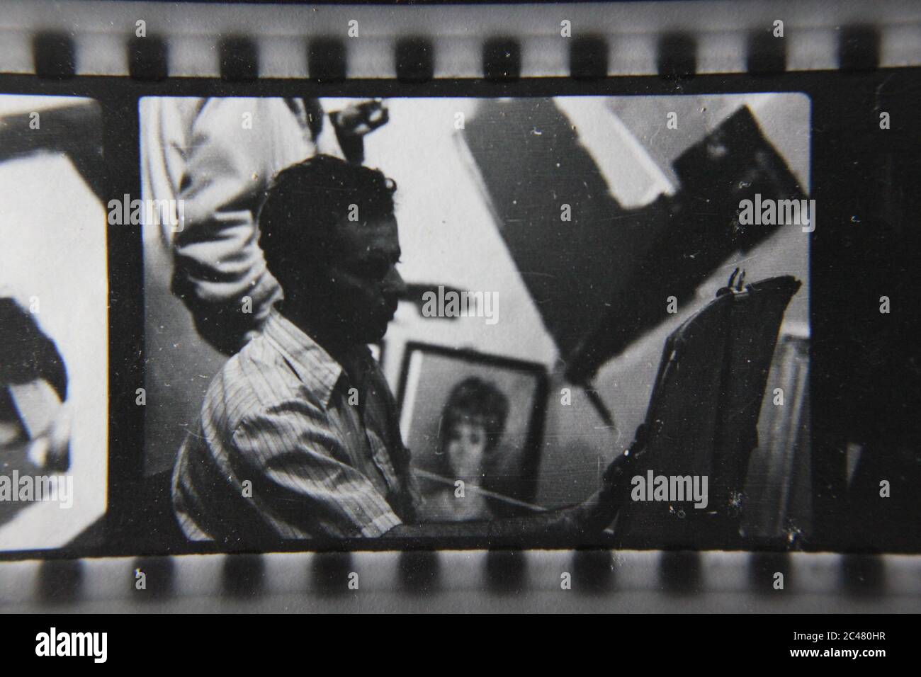Fine 70s vintage Kontakt Print schwarz-weiß Fotografie eines Straßenkünstlers Zeichnung ein Porträt von jemandem. Stockfoto