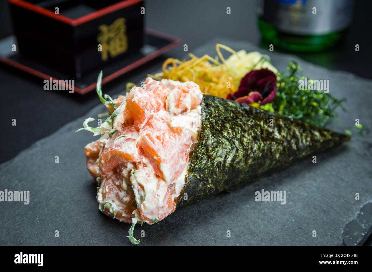 Sushi. Traditionelle japanische Küche, Premium Lachs Temaki mit Frischkäse in einem eleganten Ambiente. Stockfoto