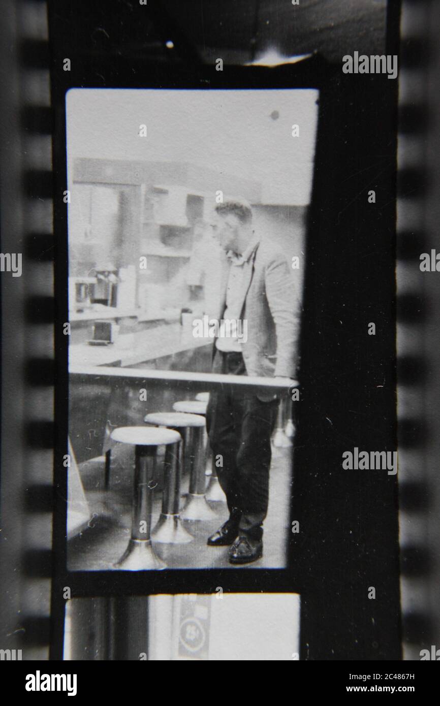 Feine 70er Jahre Vintage Kontakt Print schwarz-weiß Fotografie eines Mannes, der in einem späten Abend Diner essen. Stockfoto