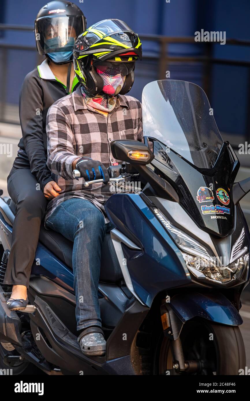 Paar auf Motorrad, mit Gesichtsmaske, während Covid 19 Pandemie, Bangkok, Thailand Stockfoto