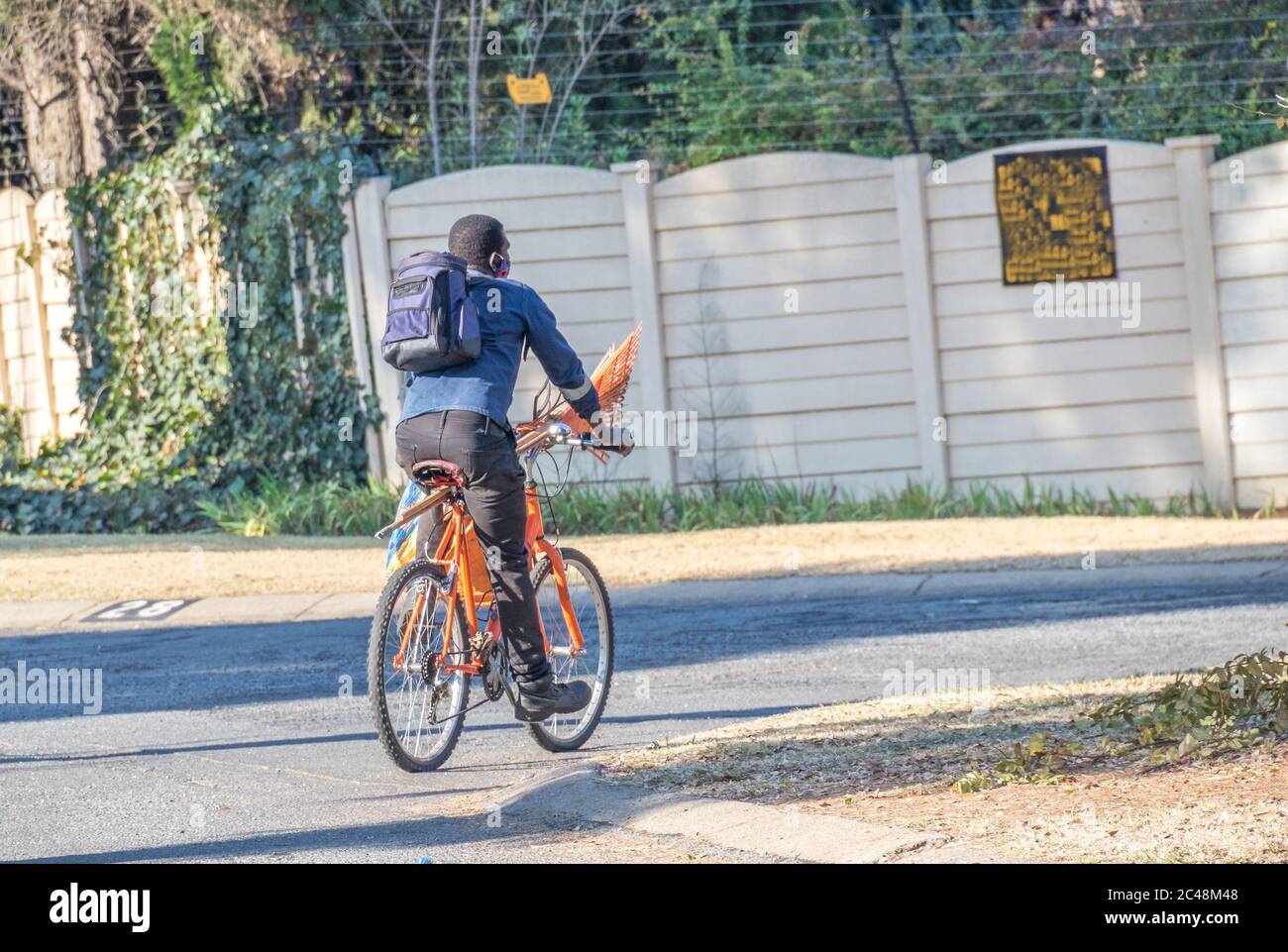 Alberton, Südafrika - unidentifizierter schwarzer Mann benutzt sein Fahrrad für den Transport, um zu seinem nächsten Gartenjob-Bild im horizontalen Format zu gelangen Stockfoto
