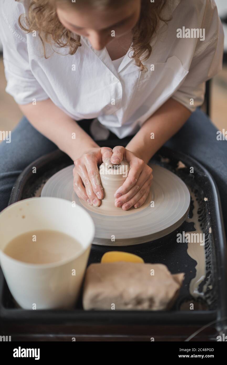 Die Hände eines Töpfers, erstellen ein irdenes Gefäß auf dem Kreis. Stockfoto