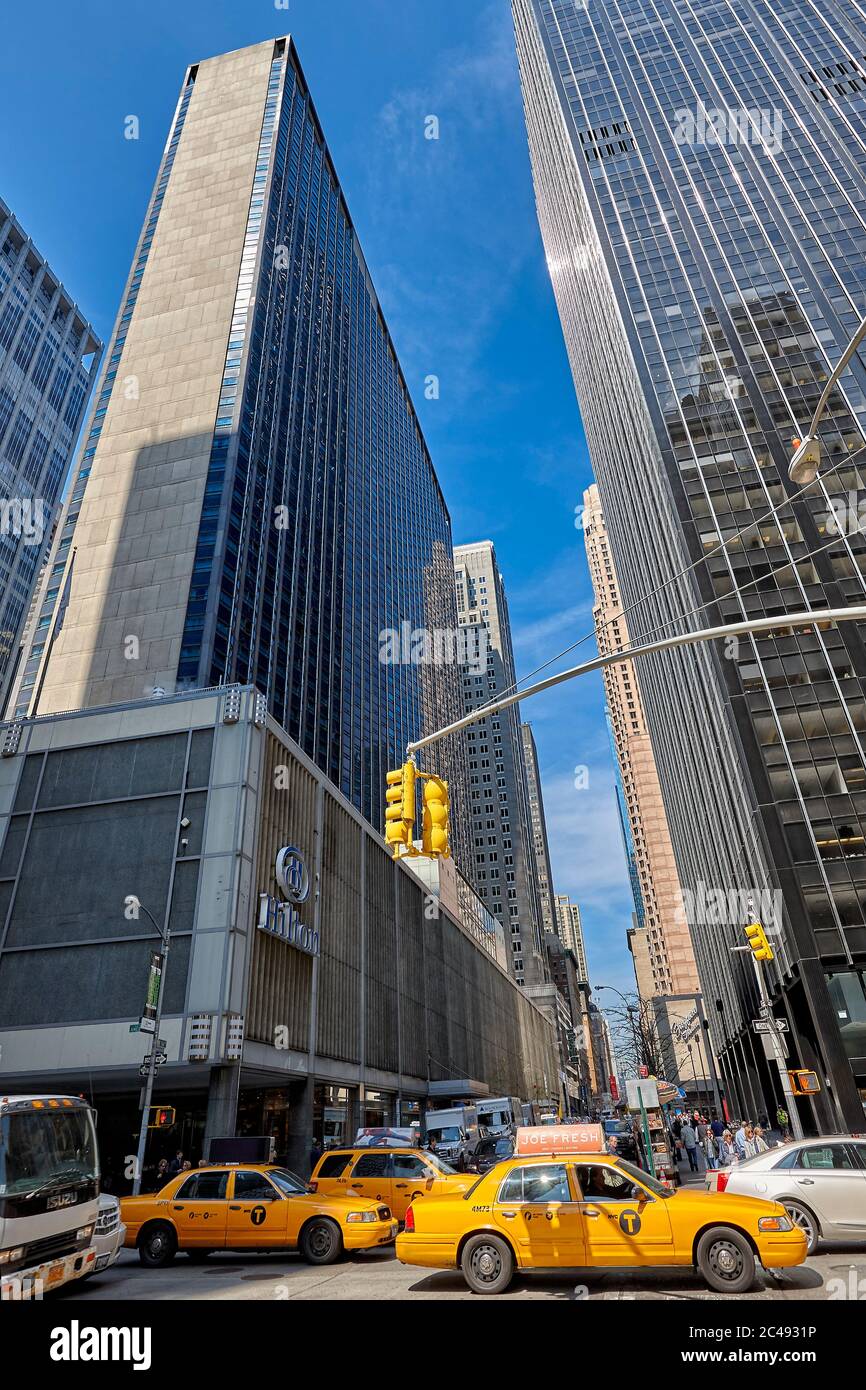 Gelbe Medaillon Taxis bewegen sich an der Kreuzung der 6th Avenue & W 54th Street. Manhattan, New York City, USA. Stockfoto