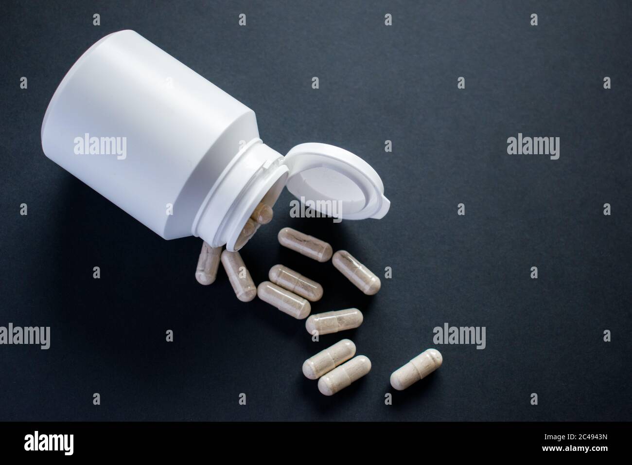 Medizinische Pillen, Tabletten mit weißen Pillenflasche auf schwarzem Hintergrund Stockfoto