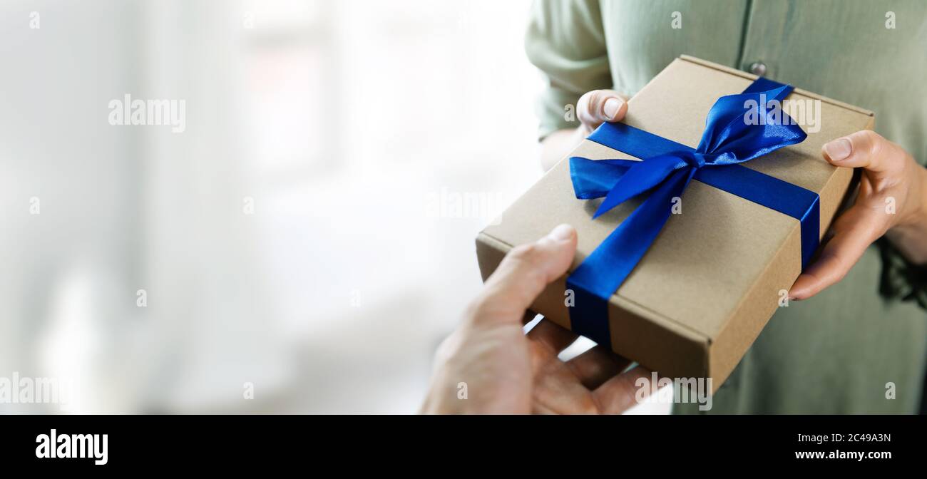 Hand geben Geschenkbox mit blauem Band zu einer Frau. Copy Raum Stockfoto