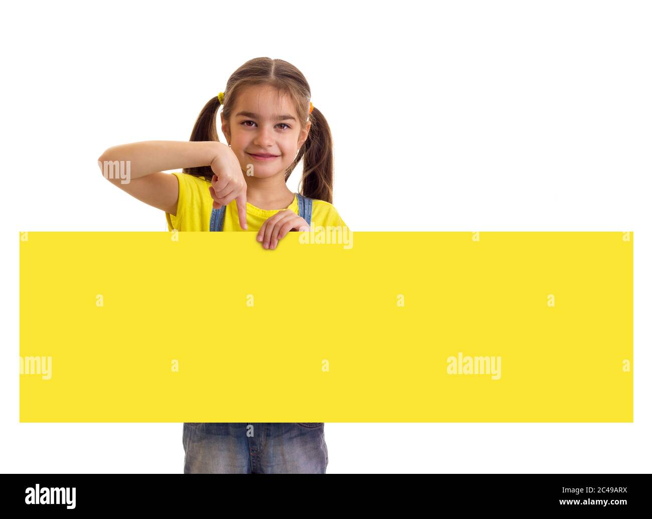 Kleines Mädchen hält lange gelbe leere Banner auf weißem Hintergrund Stockfoto
