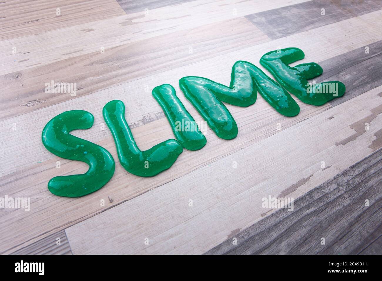 Schleimtext aus grünem Schleim auf einem Holztisch Stockfoto