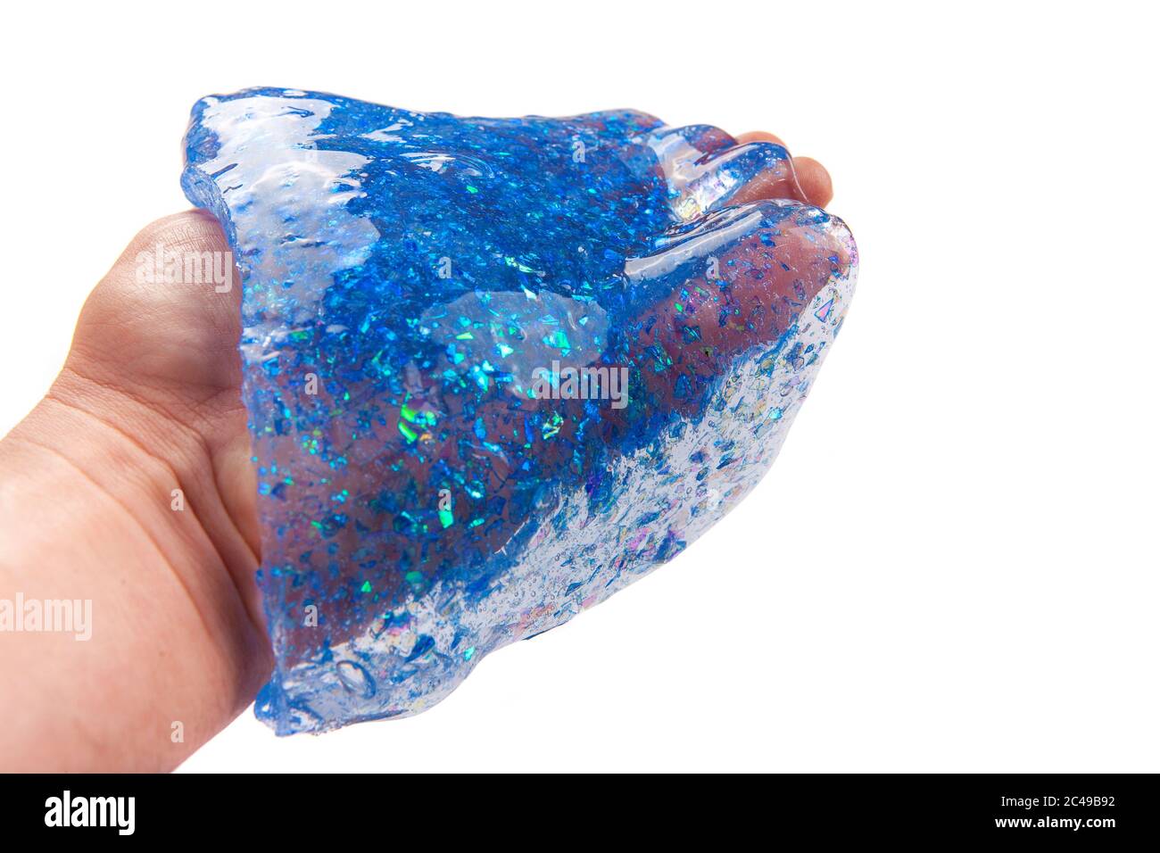 Hand hält einen blauen Glitzer Schleim isoliert auf weißem Hintergrund. Stockfoto