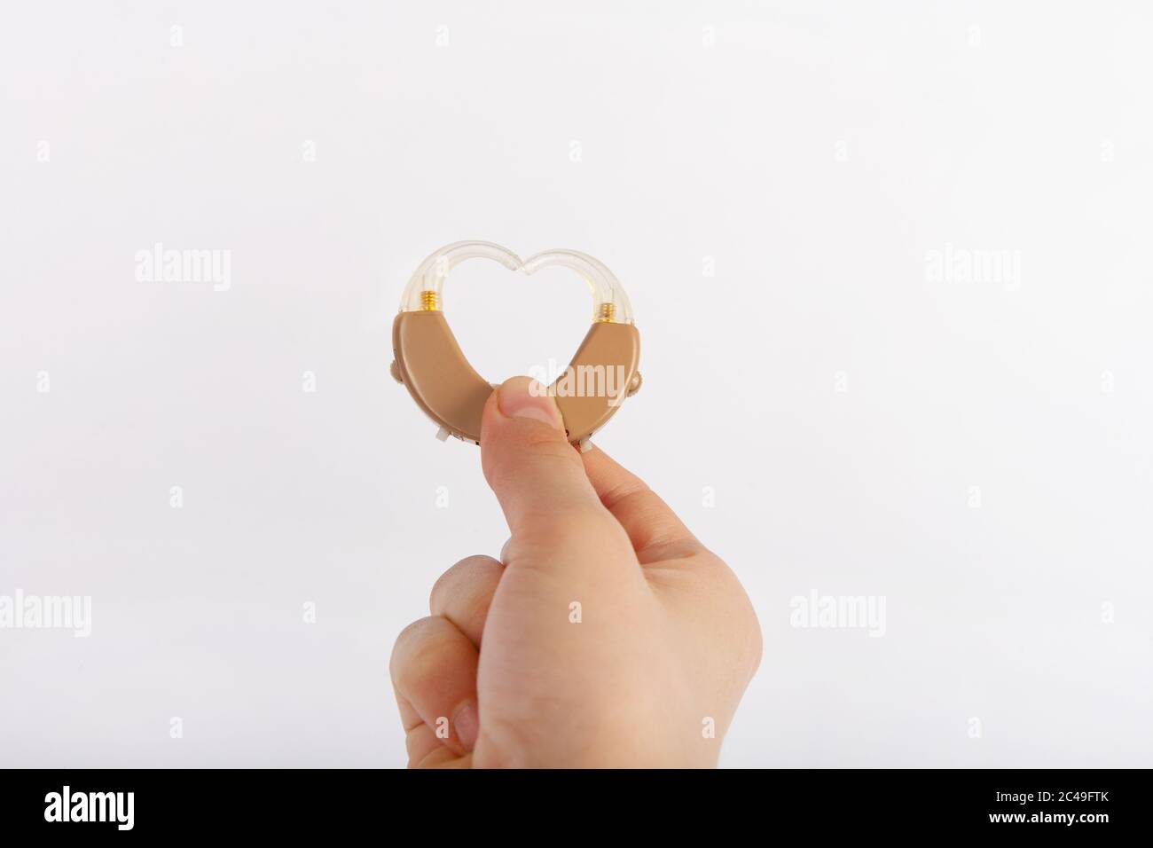 Herzform aus Hörgeräten, die von einer Hand gebildet werden Stockfoto