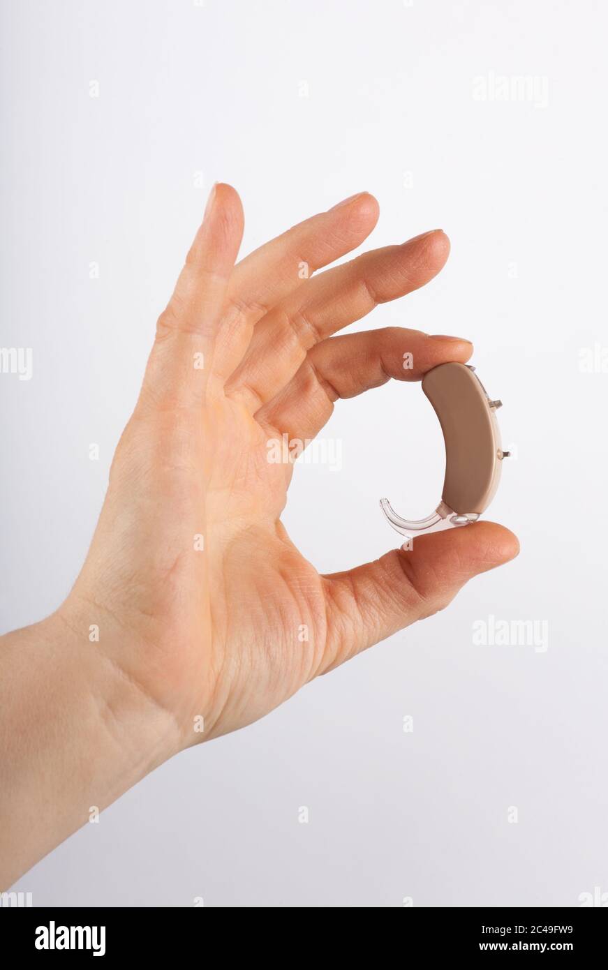Hand mit Hörgerät Stockfoto