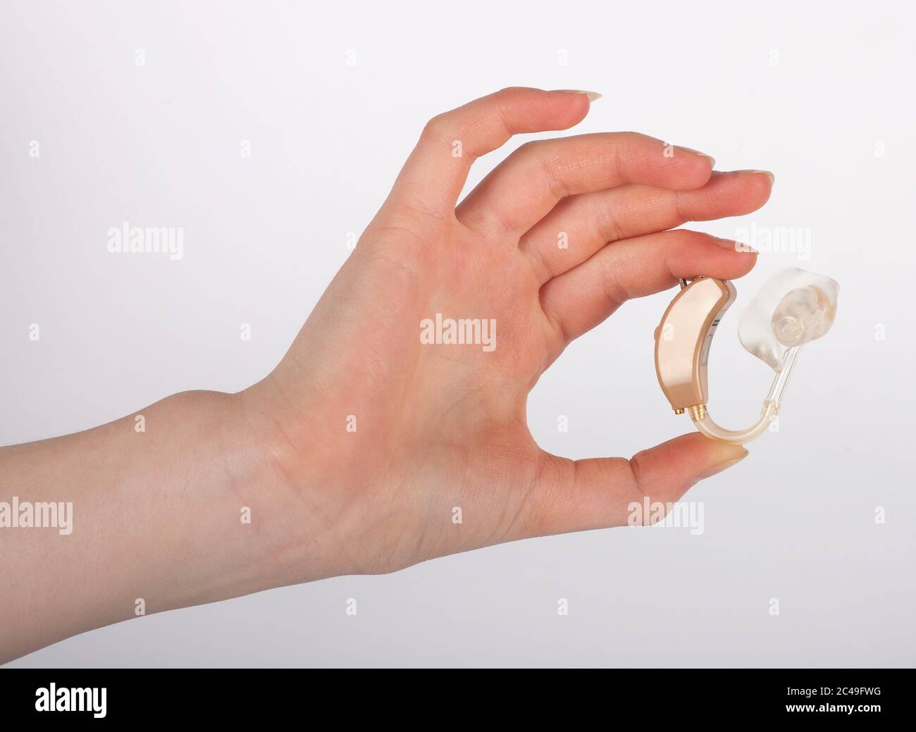 Hand mit Hörgerät und Ohrmuschel Stockfoto