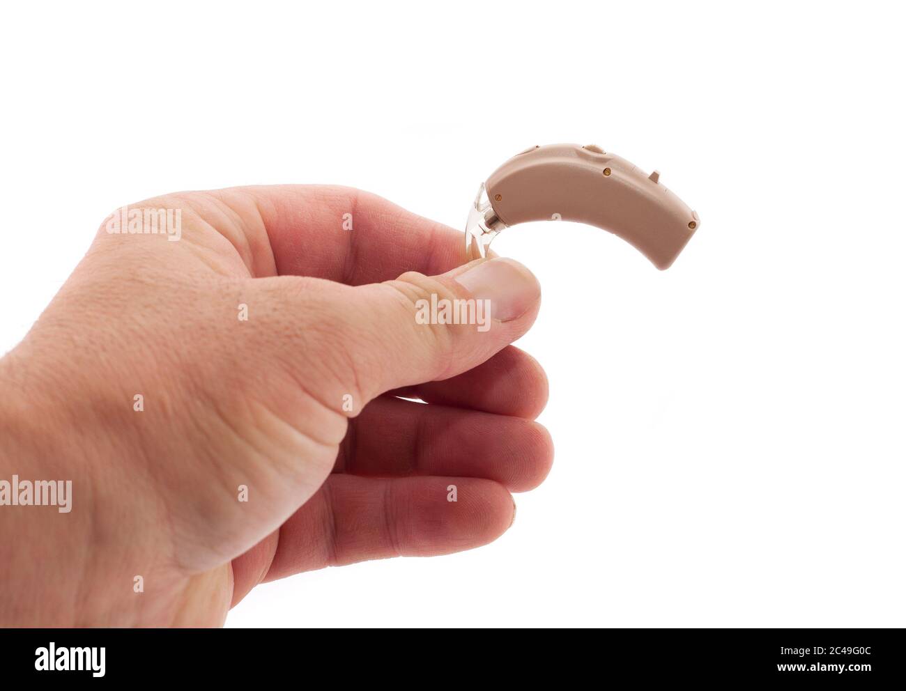 Die Hand eines Mannes zeigt ein auf Weiß isoliertes BTE-Hörgerät Stockfoto