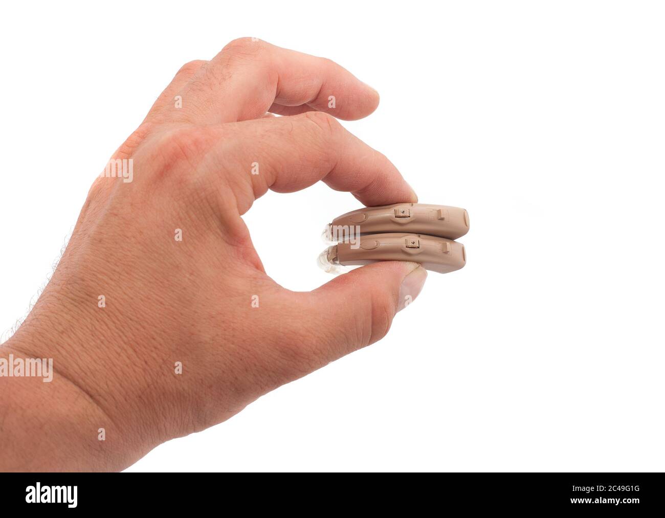 Hand mit einem Schild mit einem Paar BTE-Hörgeräten auf Weiß Stockfoto