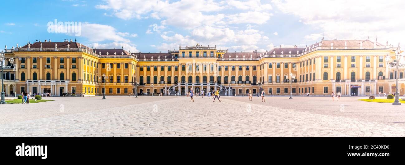 WIEN, ÖSTERREICH - 23. JULI 2019: Schloss Schönbrunn, Deutsch: Schloss Schönbrun, barocke Sommerresidenz der Habsburger Monarchen in Hietzing, Wien, Österreich. Panoramablick auf die Fassade vom Haupthof. Stockfoto