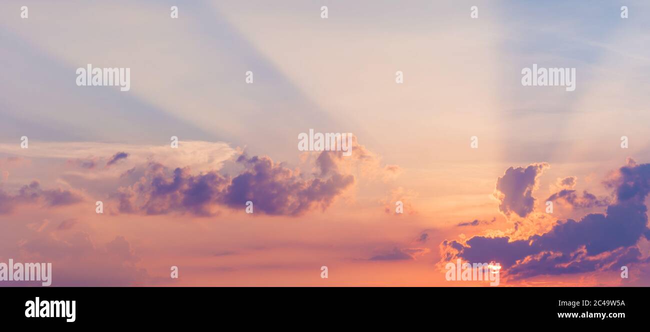 Schöner Himmel mit Sonnenstrahlen. Majestätische bunte Wolken in Pastelltönen. Stockfoto