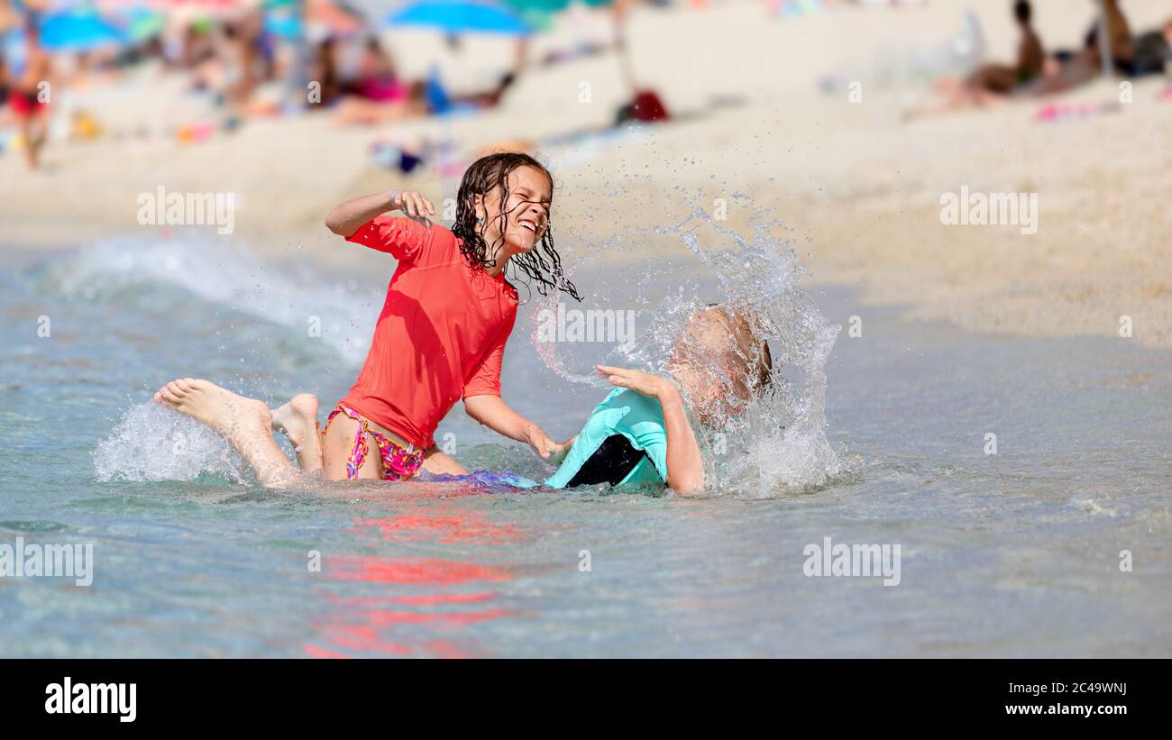 Sommerkonzept mit Jungen und Mädchen spielen am Strand Stockfoto