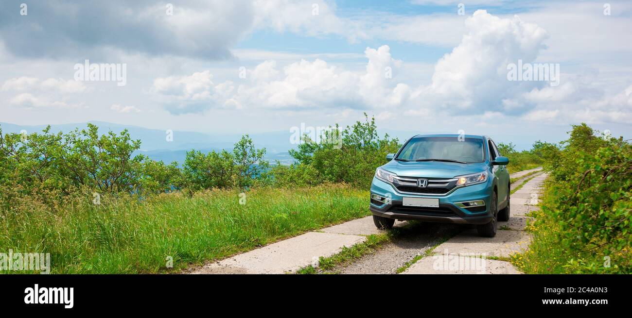 Mnt. runa, ukraine - 22. JUN 2019: Cyan honda cr-V suv auf der Bergstraße. Erkunden Sie das Wildnis-Konzept. Grat in der Ferne. Sonniges Wetter. clo Stockfoto