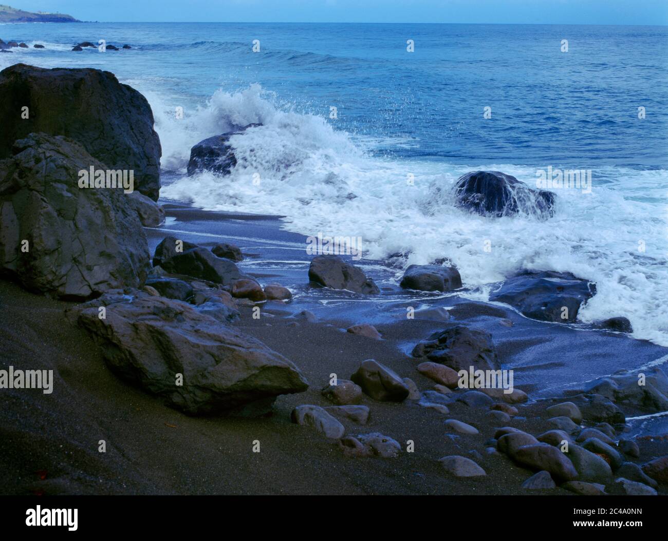 Black Rocks St. Kitts Wellen krachen auf Rocks on Beach Stockfoto