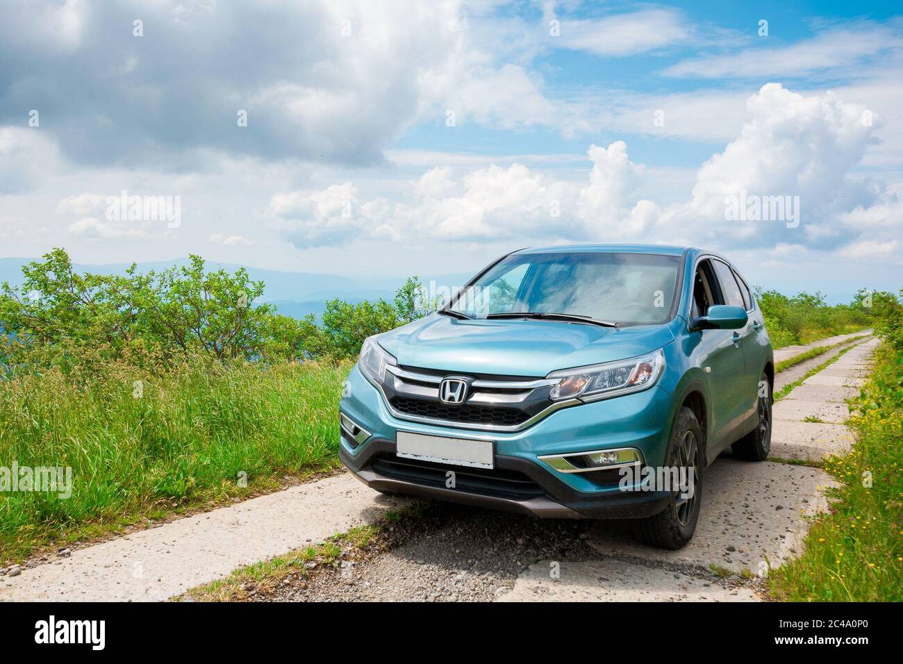 Mnt. runa, ukraine - 22. JUN 2019: Cyan honda cr-V suv auf der Bergstraße. Erkunden Sie das Wildnis-Konzept. Grat in der Ferne. Sonniges Wetter. clo Stockfoto