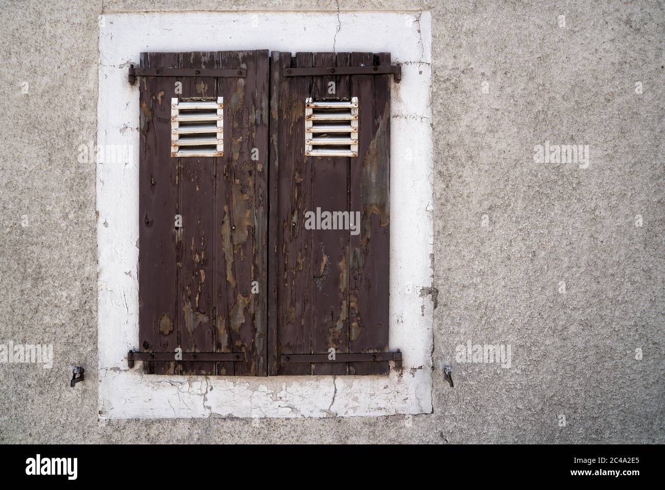 Ein alter wettergetragener Fensterverschluss in Sainte-Croix, Schweiz. Stockfoto