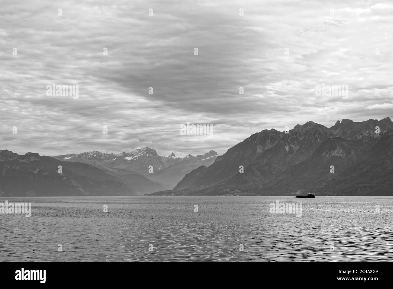 Ein landschaftlich schöner Blick auf den Genfer See mit einem Schiff. Der See ist mit einer Größe von 345 km² einer der größten in Westeuropa. Stockfoto