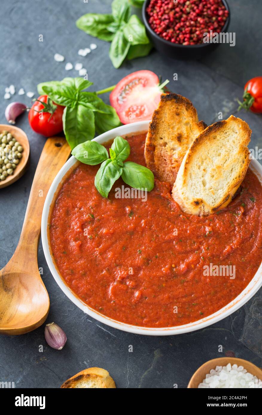 Frische hausgemachte Tomatensuppe in der Schüssel auf Steingrund Stockfoto