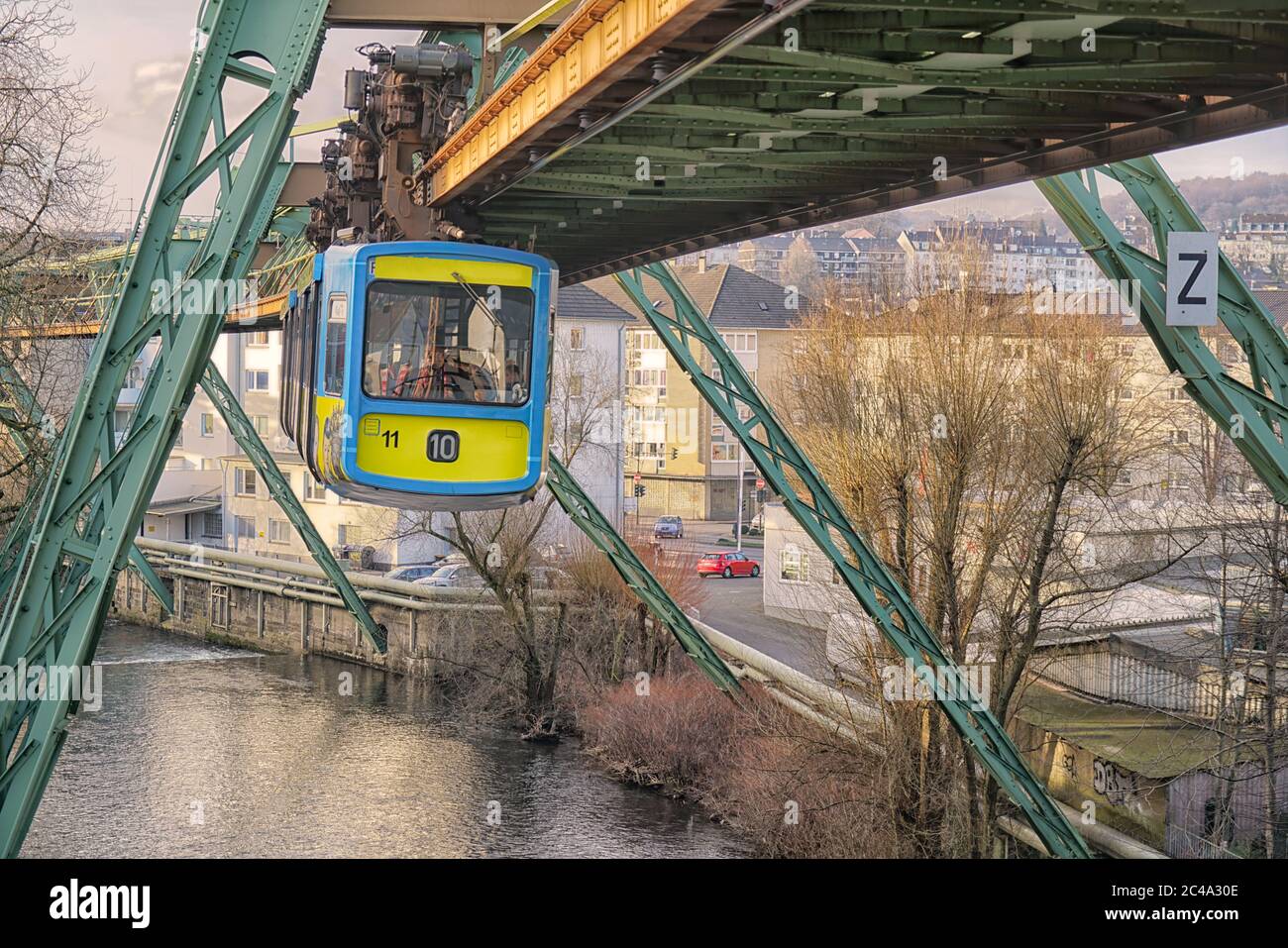 Ein Zug der Wuppertaler Schwebebahn fliegt über den Fluss. Dieses System ist einzigartig auf der Welt. Stockfoto