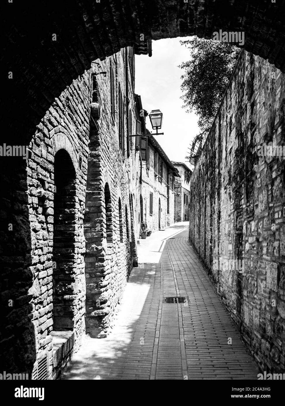 Malerische mittelalterliche schmale Straße von San Gimignano Altstadt, Toskana, Italien. Schwarzweiß-Bild. Stockfoto