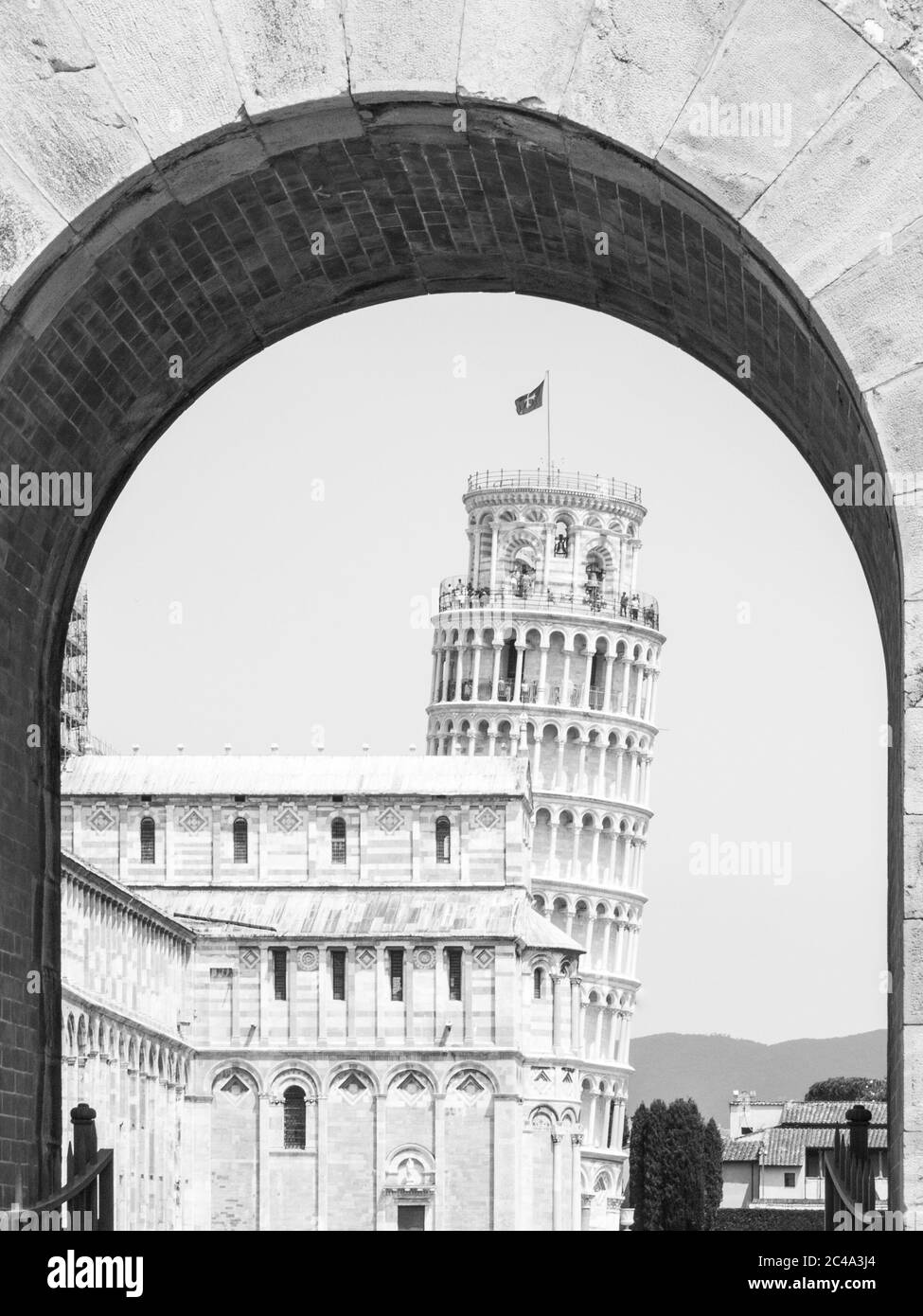 Schiefer Turm in Pisa, Torre pendente di Pisa. Blick durch den Bogen des Neuen Tores, Porta Nuova. Toskana, Italien, UNESCO-Weltkulturerbe. Schwarzweiß-Bild. Stockfoto