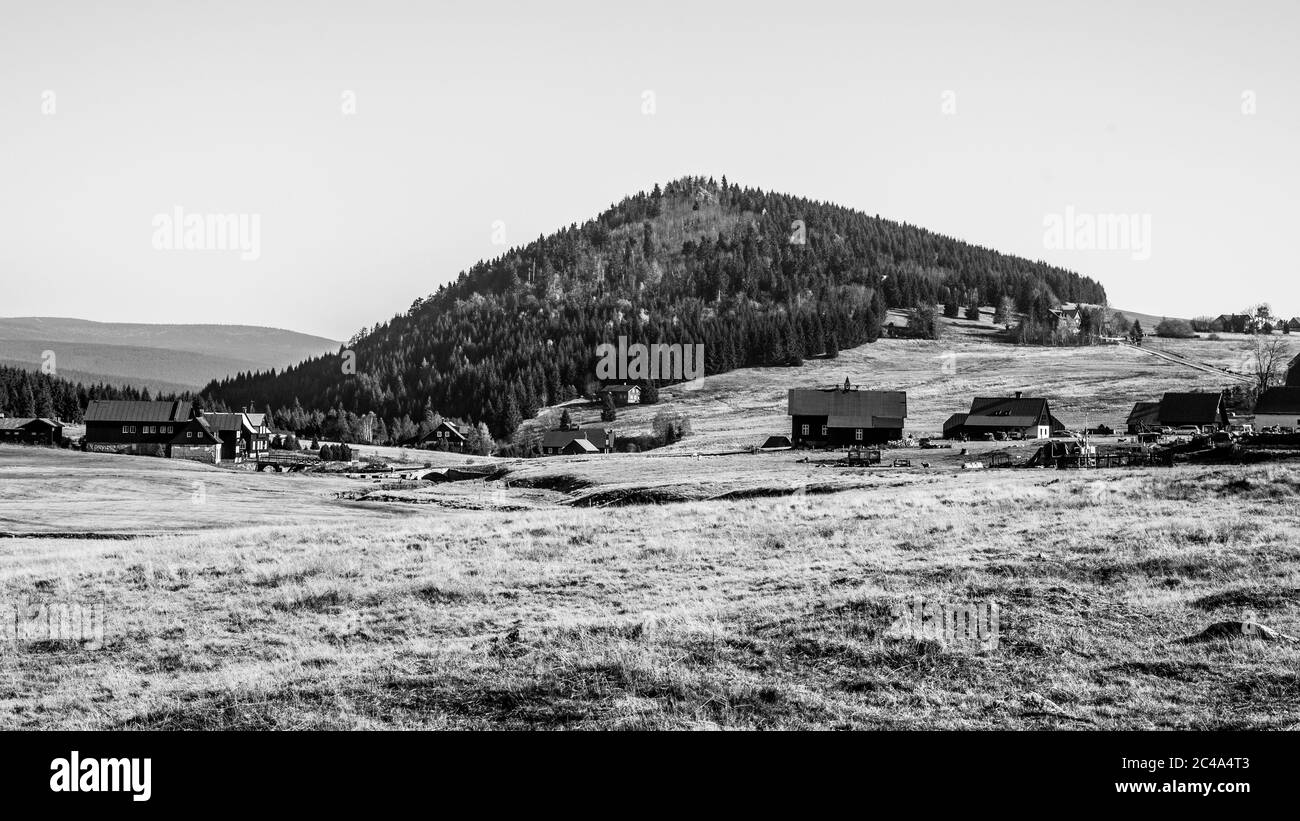 Berg Bukovec oberhalb des Dorfes Jizerka im Isergebirge, Tschechische Republik. Klarer sonniger Tag. Schwarzweiß-Bild. Stockfoto