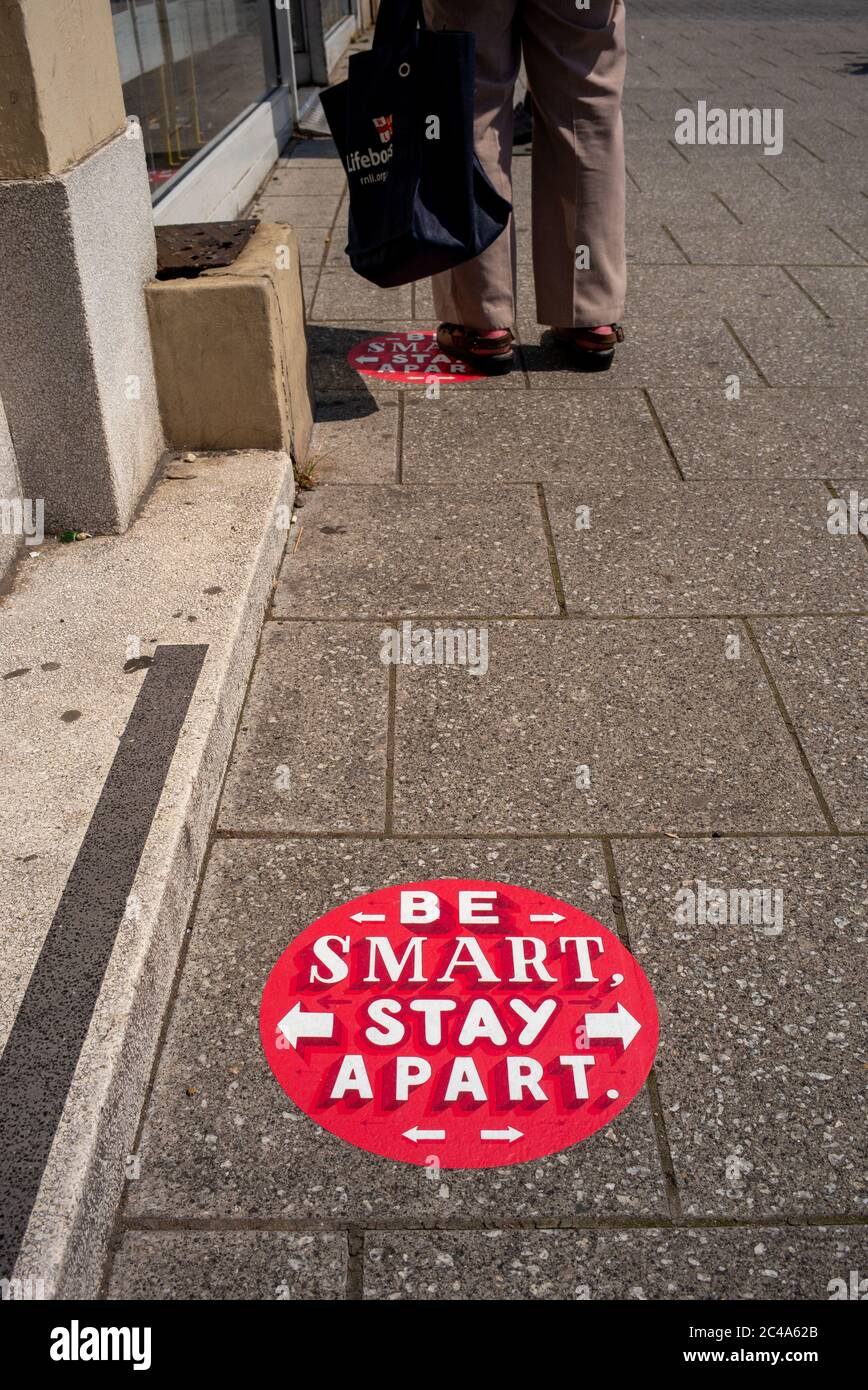 Soziale Distanzierungszeichen auf dem Bürgersteig während der Coronavirus-Pandemie vor dem Postamt in Portswood Southampton. Seien Sie klug Bleiben Sie auseinander. Stockfoto