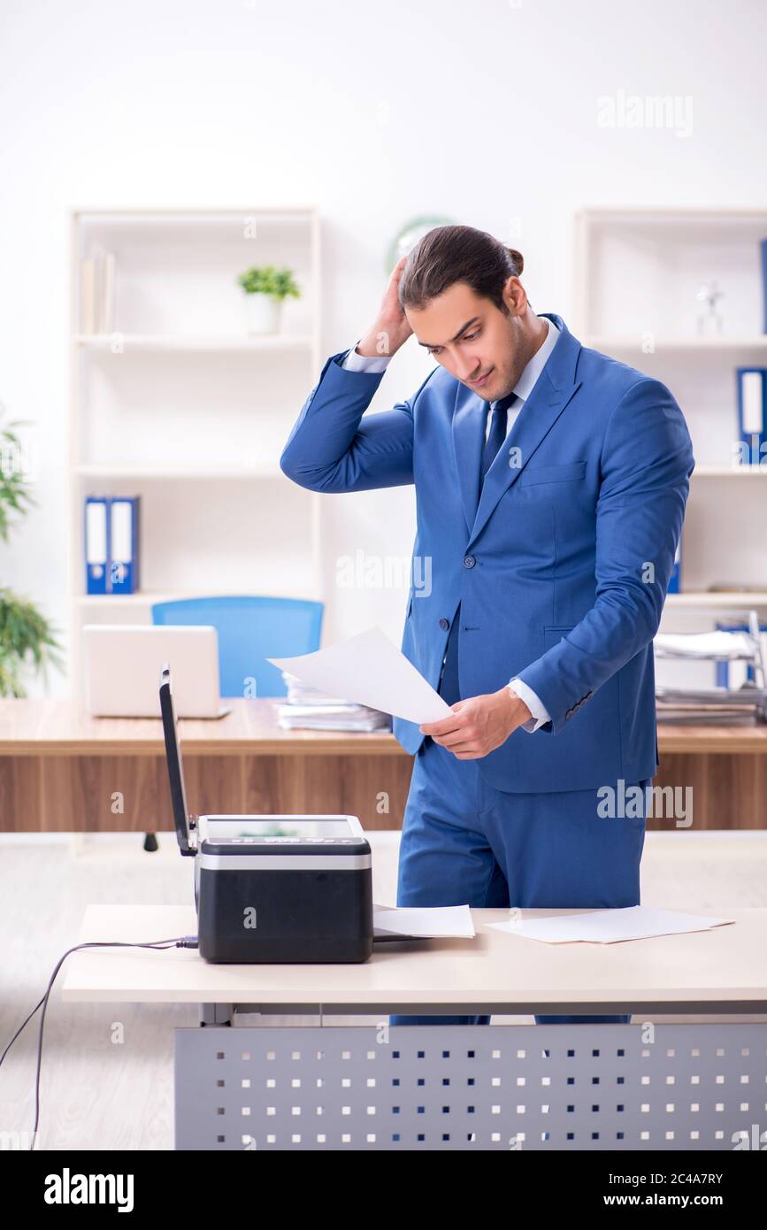 Junge Mitarbeiter von Kopien beim Kopieren von Maschine Stockfoto