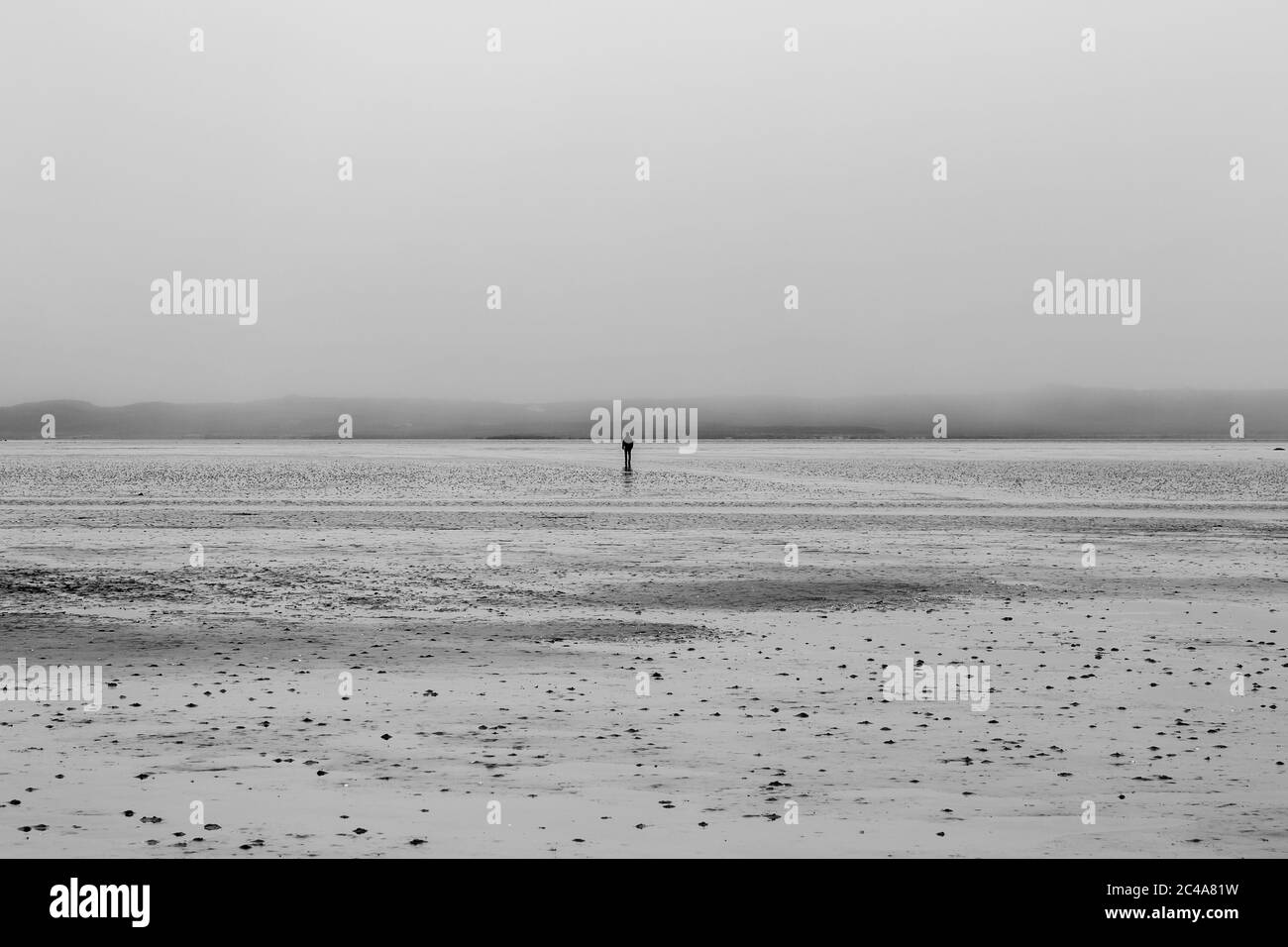 Eine einsamen Figur in der Entfernung zu Fuß zur Insel Vallay von North Uist, bei Ebbe Stockfoto