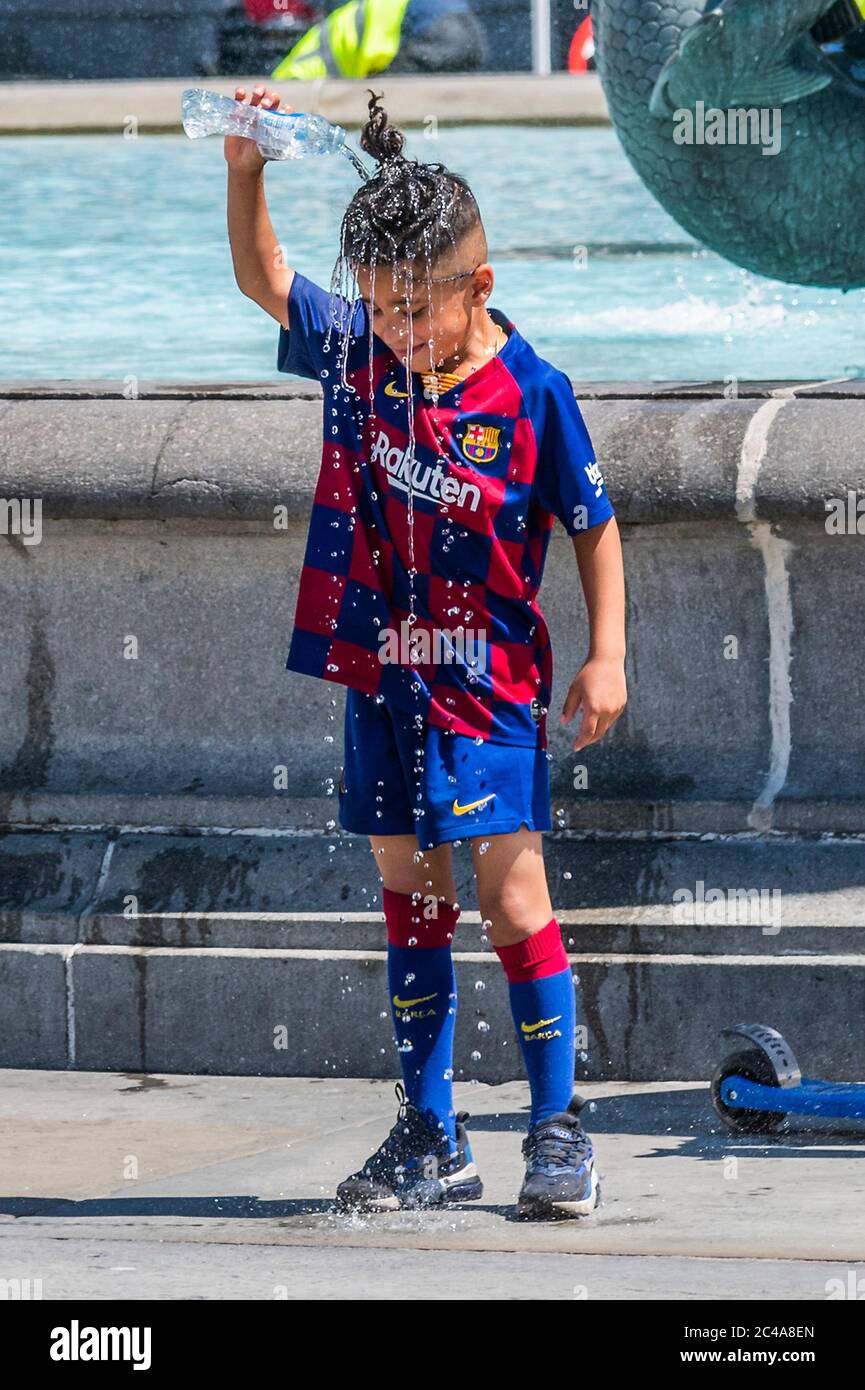 London, Großbritannien. Juni 2020. Eine Mutter und ein Sohn haben Spaß mit einer Trinkflasche aus dem Brunnen gefüllt - das Wasser in den Brunnen ist verlockend, aber Sicherheitsleute schnell erscheinen, wenn die Menschen versucht sind, einen Zeh einzutauchen - genießen die Sonne auf Trafalgar Square an möglicherweise dem heißesten Tag der Jahr. Die „Lockdown“ wird nach wie vor für den Coronavirus (Covid 19) Ausbruch in London gelockert. Kredit: Guy Bell/Alamy Live Nachrichten Stockfoto