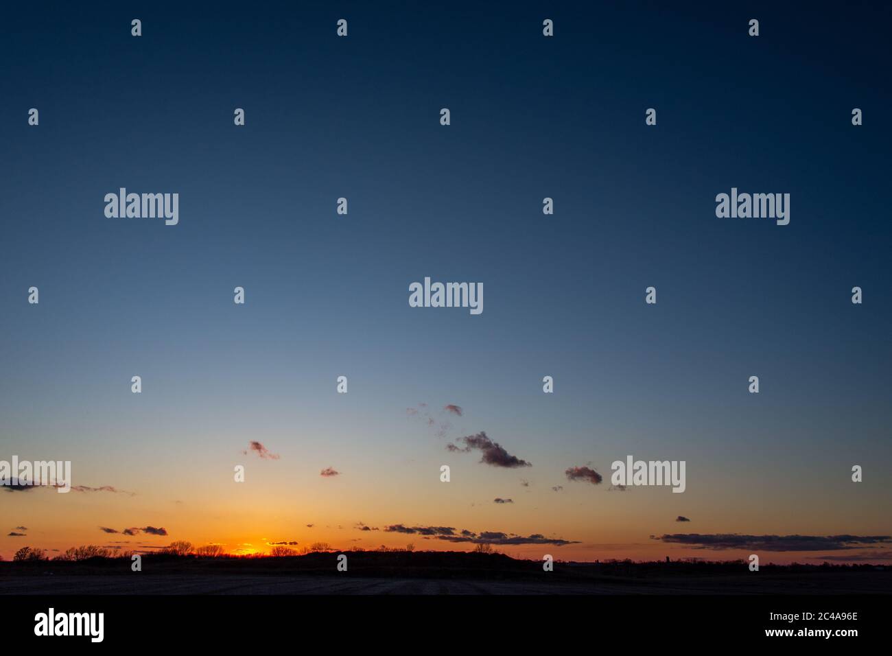 Die untergehende Sonne taucht unter dem Horizont in Ankeny, Iowa. Stockfoto