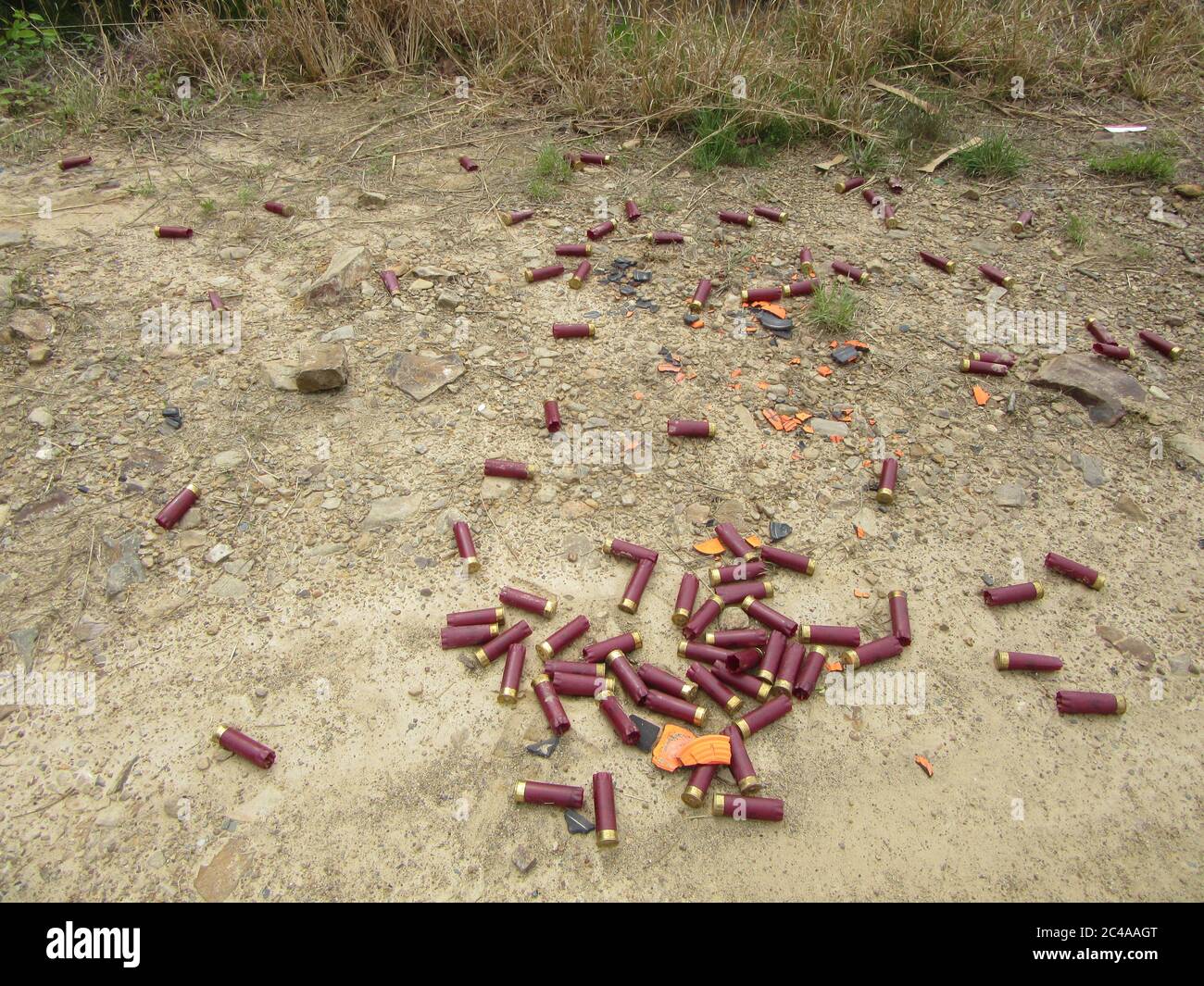 Viele weggeworfene, verbrauchte Schrotflinten liegen auf dem Boden Stockfoto