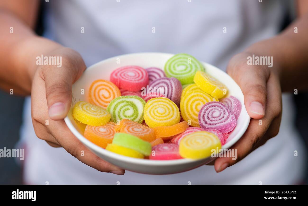 Nahaufnahme Hand hält eine Schüssel von Gelee Candy Vielfalt von Farben Stockfoto
