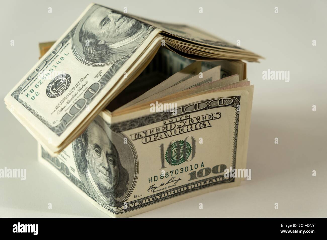 Mini-Haus der Dollar-Banknote. Konzept der Investitionsimmobilie, Hypothek Konzept. Investitionsrisiko und Unsicherheit Stockfoto