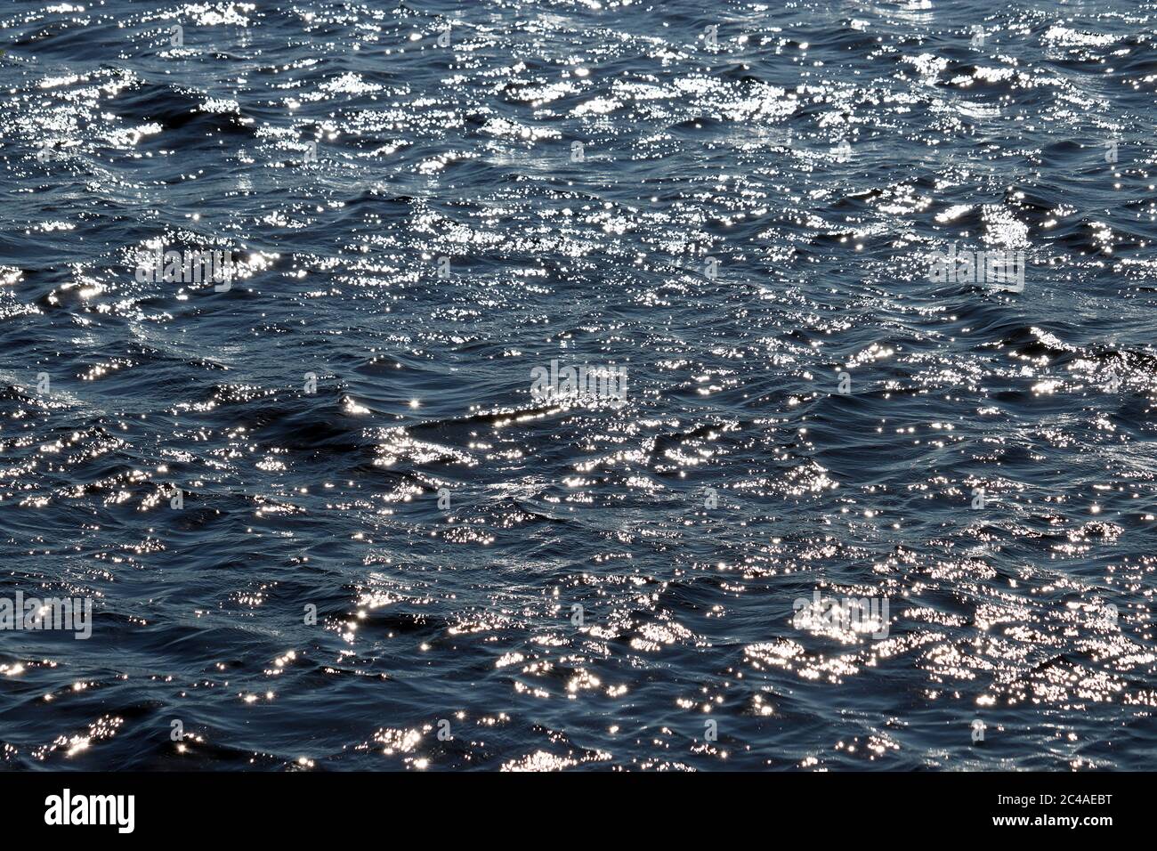 Glitzernde Wasseroberfläche Textur des tiefblauen Meeres. Weiche Wellen, Wellenwasser als Hintergrund Stockfoto