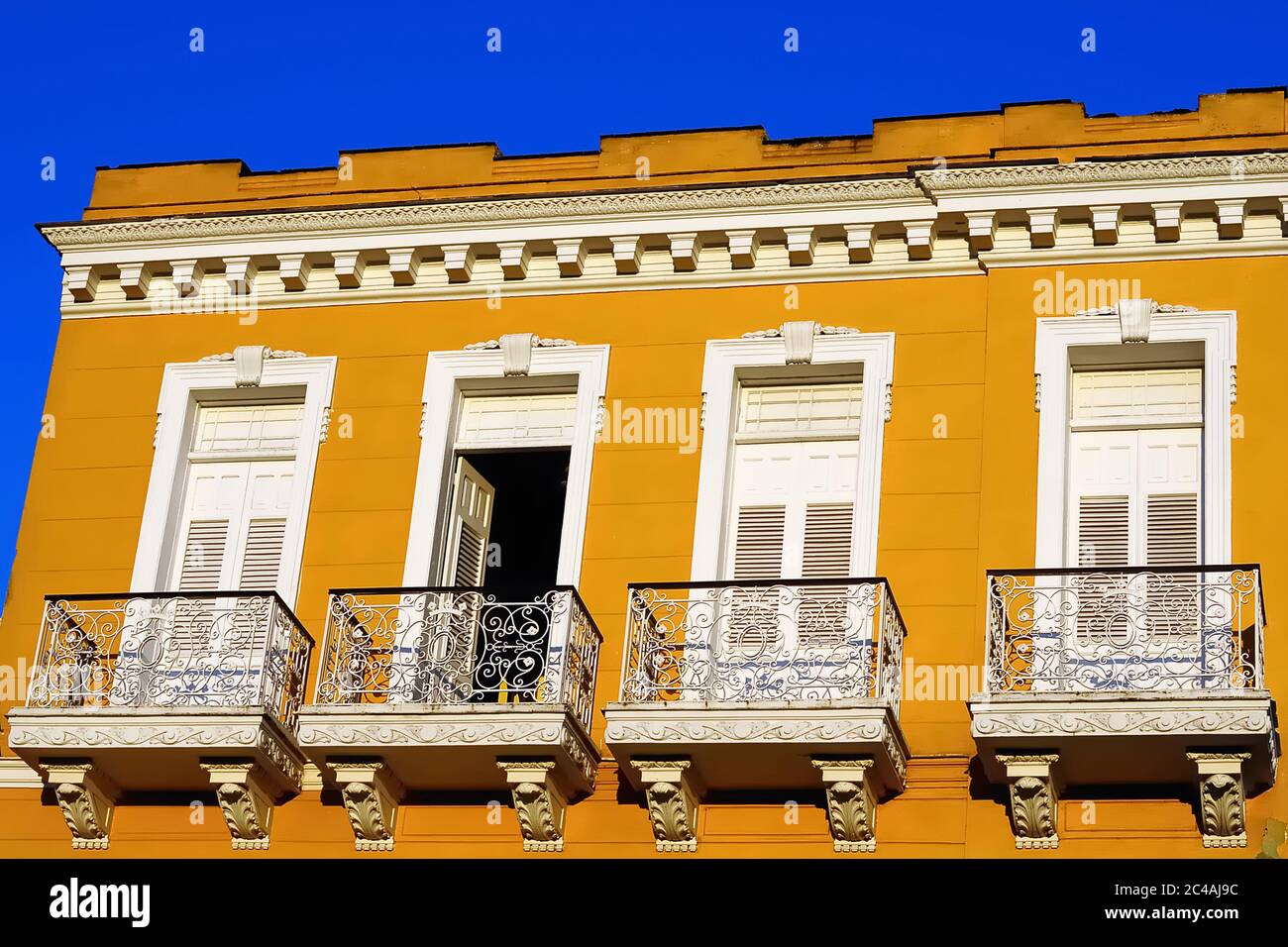 Koloniale gelbe Bebauung mit weißen Balkonen in Sancti Spiritus, Kuba Stockfoto