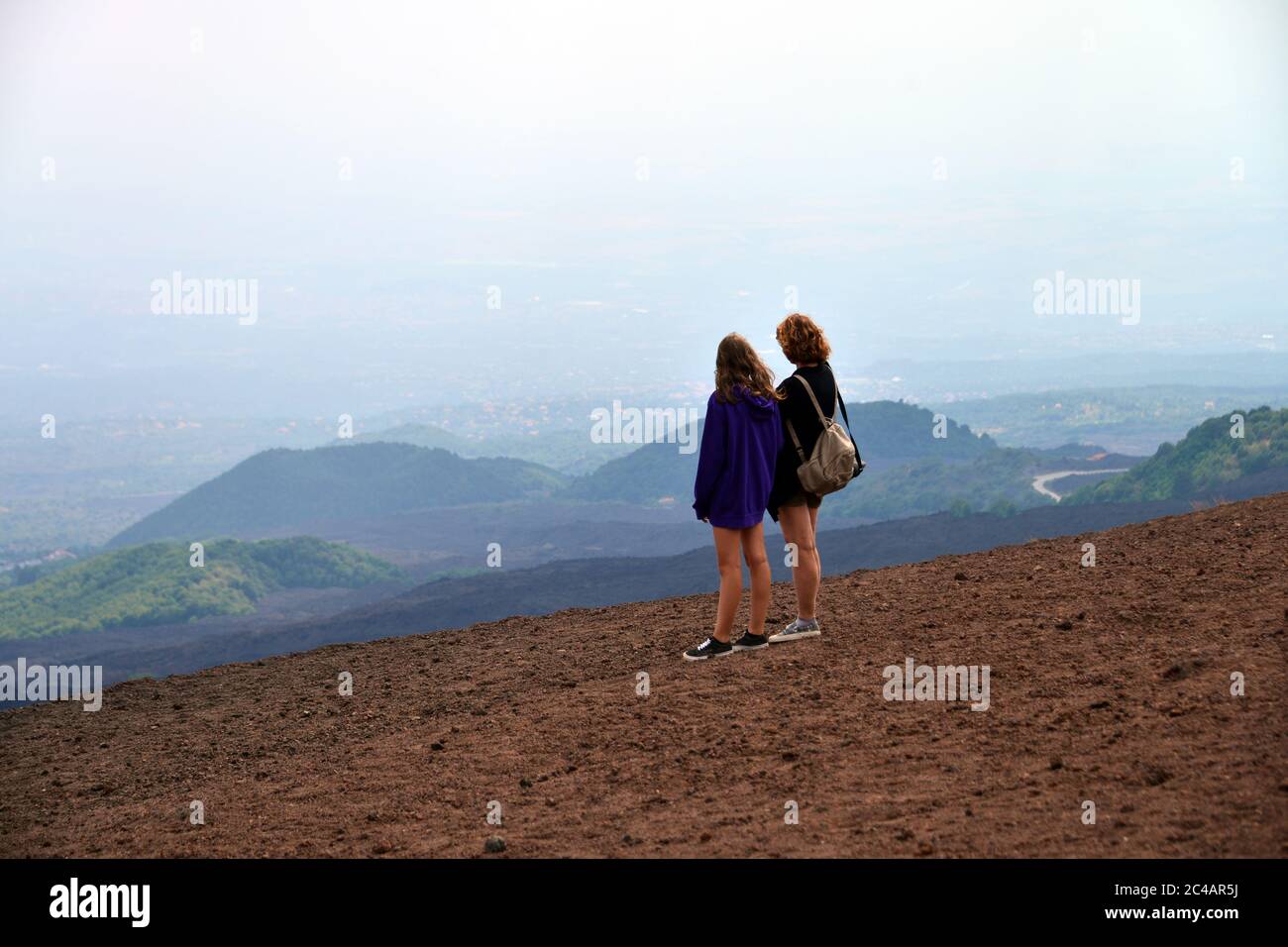 Zwei Mädchen schauen sich den Blick von oben auf den Vulkan Ätna an Stockfoto