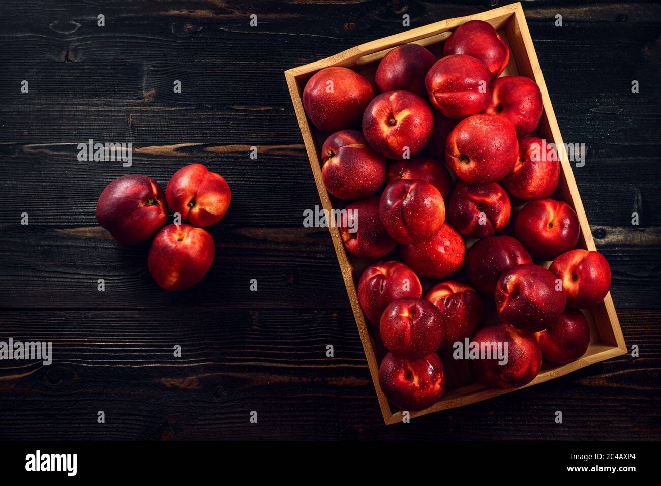 Reife Nektarine Pfirsichfrüchte auf dunklem Holztisch Stockfoto