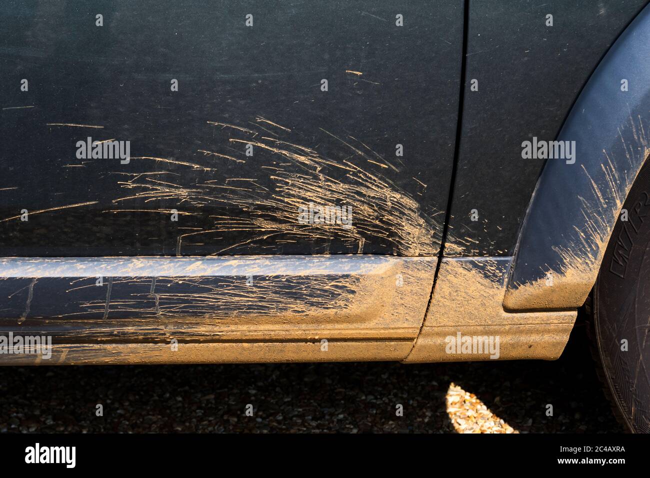Schlamm, der um das Vorderrad des SUV geworfen wurde, nachdem er durch Wasserpfützen abseits der Straße gefahren wurde. Stockfoto