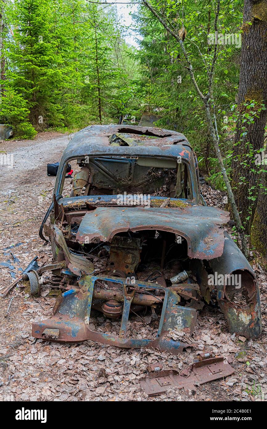 KIRKOE MOSSE, SCHWEDEN - 30. MAI 2020: Ein Autofriedhof in einem Wald bei Kirkoe Mosse, Schweden. Stockfoto