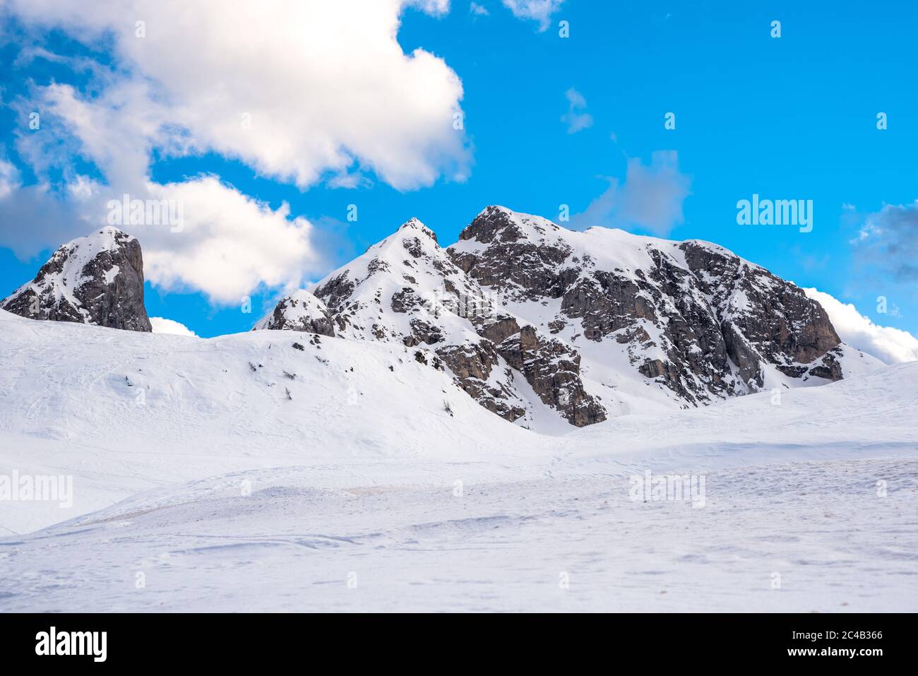 Slow bedeckter felsiger Gipfel in den europäischen Alpen unter blauem Himmel an einem Wintertag Stockfoto