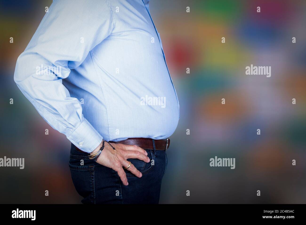 Mann mit einem großen Bauch trägt ein Hemd und Jeans, Seitenansicht Stockfoto